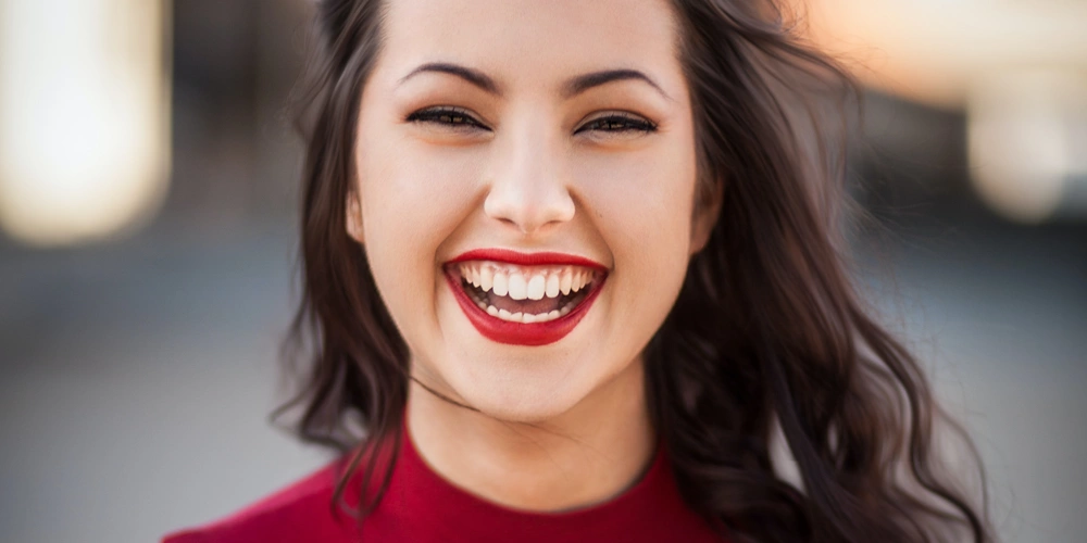 An adult women smiling after getting dental sealants