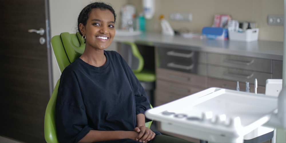 A women smiling and feeling great after her post bone graft procedure appointment