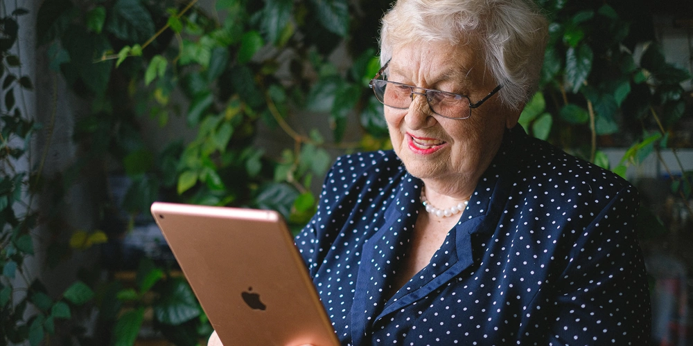A aged women looking up the benefits of Xenograft bone on a tablet