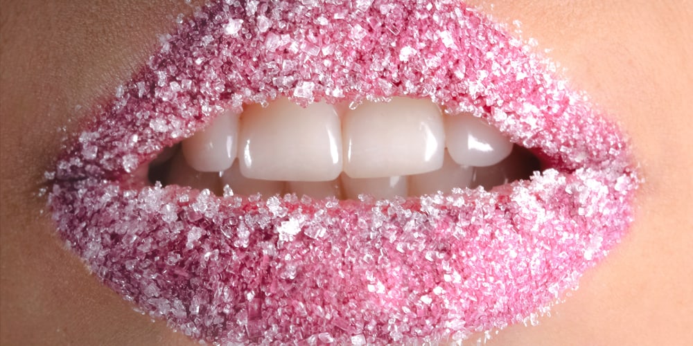 A women with sugar and pink liptick showing her very white zirconia veneers
