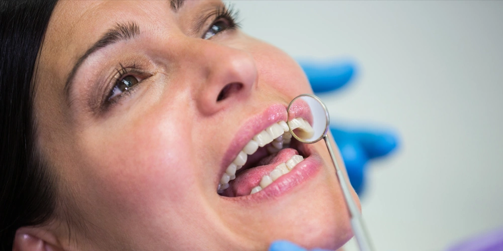 A patient have her dental sealants inspected by her dentist
