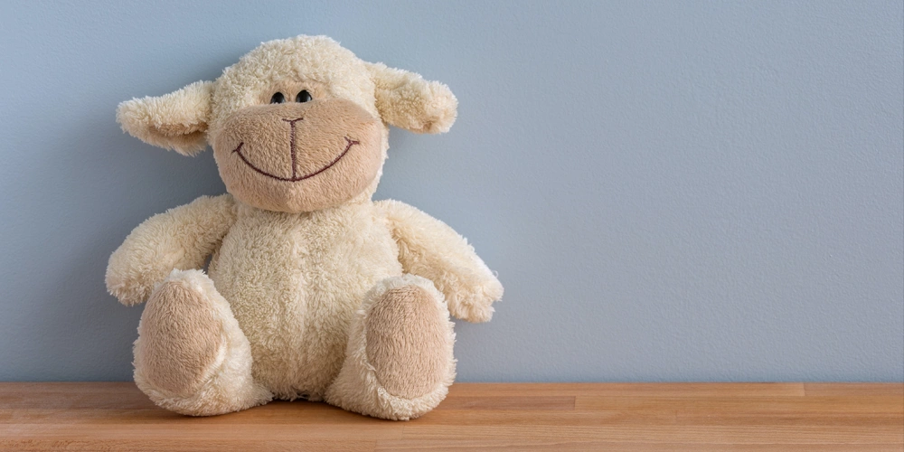 A stuffed lamb toy smiling to support the comfort received when using intravenous sedation for dental procedures
